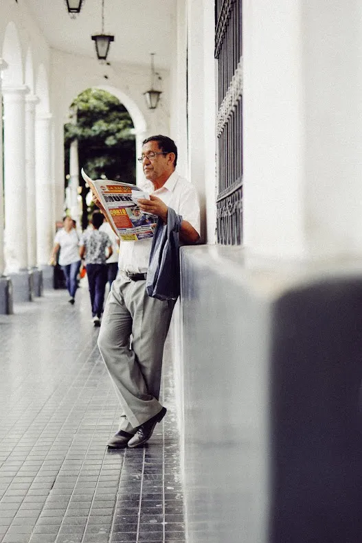 Persona leyendo un periódico en la calle, desenfoque de fondo